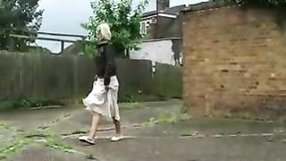 Busty blonde babe peeing behind a garage