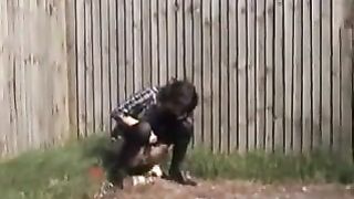 British babe peeing on a wooden fence