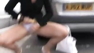 Sexy girl peeing behind parked car