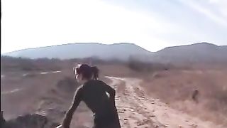 Dark haired girl peeing in nature