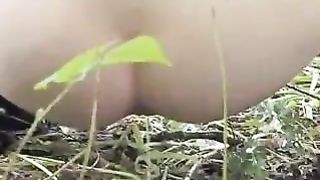 Young girl peeing in the woods