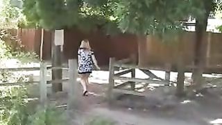 Blonde milf peeing near a wooden fench