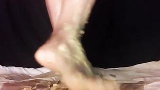 Smearing yellow shit on her feet