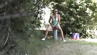 Two girls peeing behind a tree